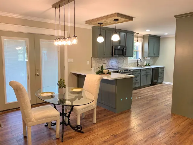 a kitchen with a table chairs and wooden floor