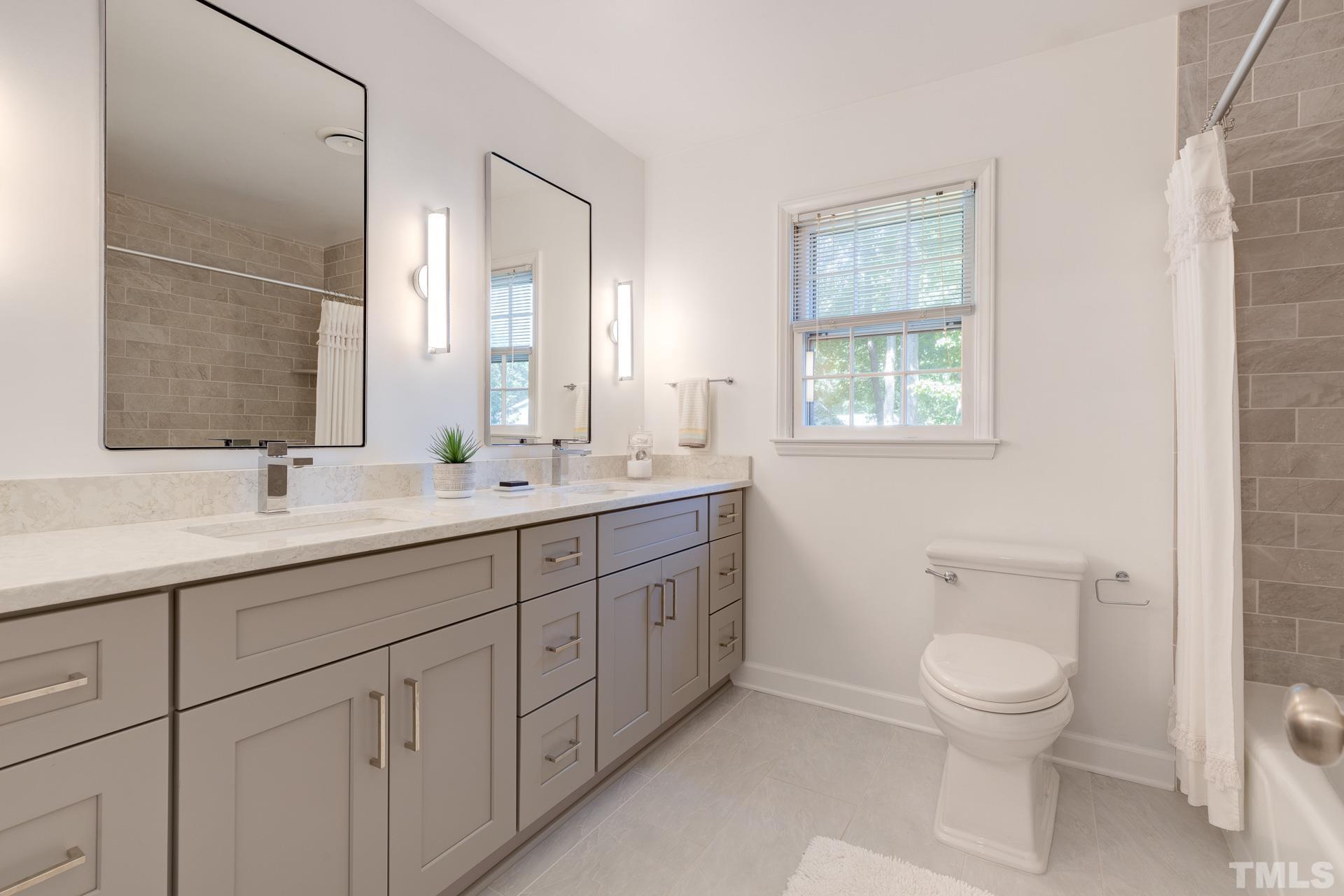 613 Ortega Road Raleigh, NC 27609 - Photo 26 of 37 a bathroom with 2 sink toilet and a mirror