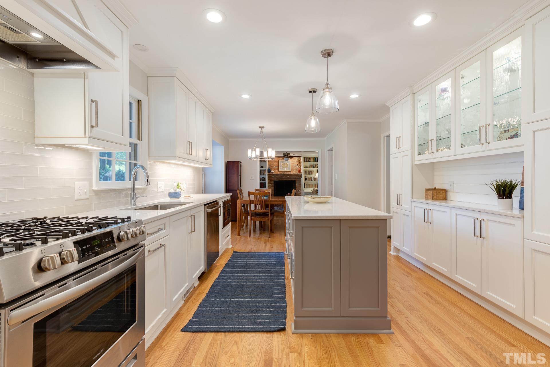 613 Ortega Road Raleigh, NC 27609 - Photo 8 of 37 a kitchen with wooden floors and cabinets