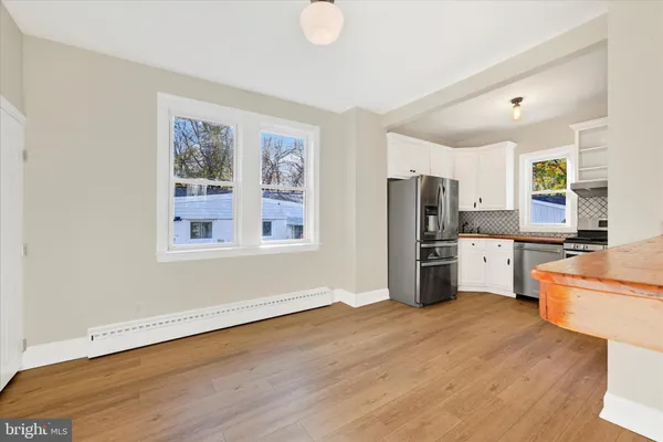 a view of a big room with wooden floor and windows