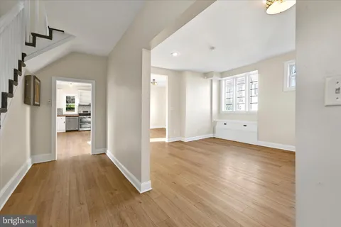 a view of a big room with wooden floor and a kitchen
