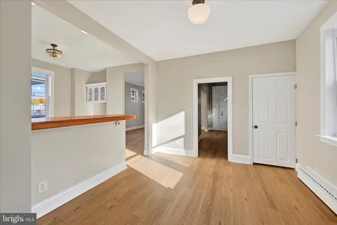 a view of a big room with wooden floor and windows