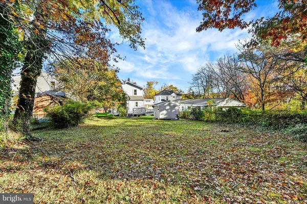 a view of a big house with a big yard and large trees