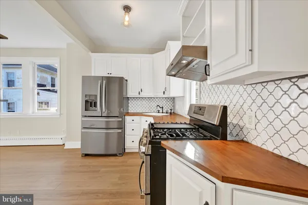 a kitchen with stainless steel appliances and wooden floor