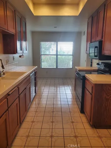 a kitchen with a sink a stove cabinets and a window