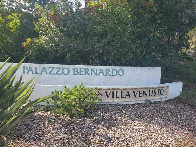 a sign that is sitting in front of a tree