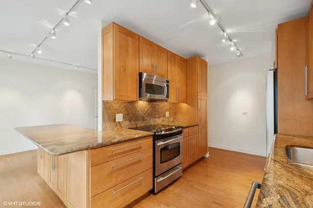 a kitchen with stainless steel appliances granite countertop a sink stove and refrigerator