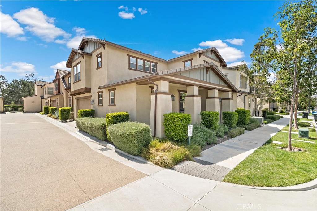 91 Barnes Road Tustin, CA 92782 - Photo 2 of 2 a view of a white house with a yard and potted plants
