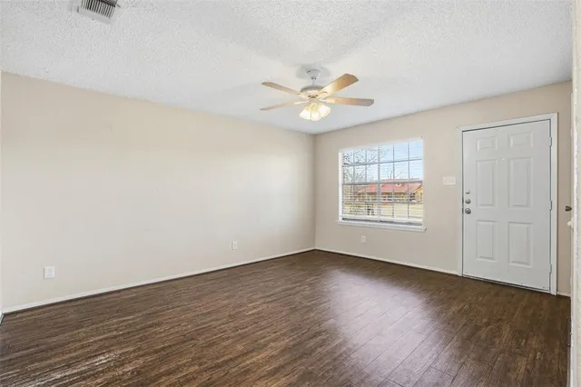 an empty room with wooden floor and window