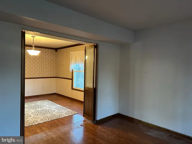 a view of a big room with wooden floor and windows