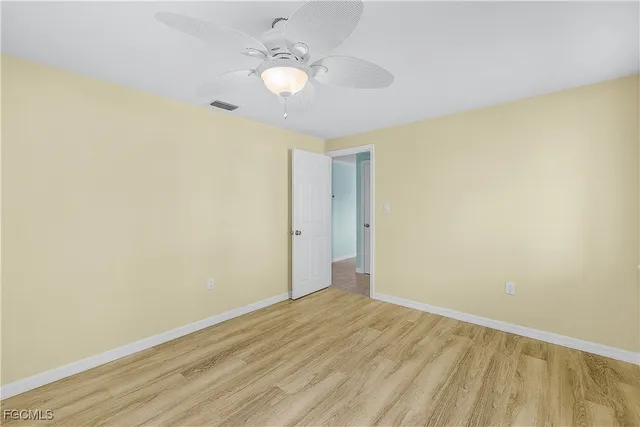 a view of an empty room and chandelier fan