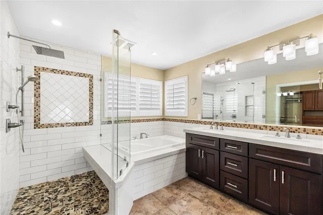 a spacious bathroom with a tub sink and mirror