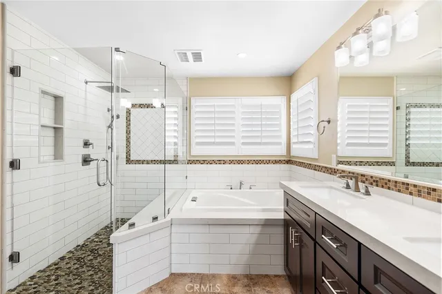 a bathroom with a tub sink and mirror