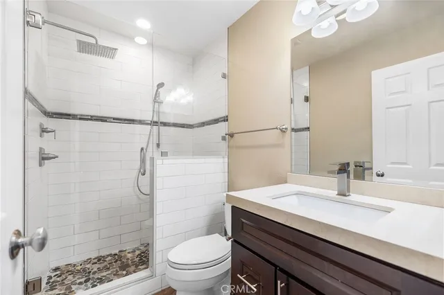 a bathroom with a sink toilet vanity and shower