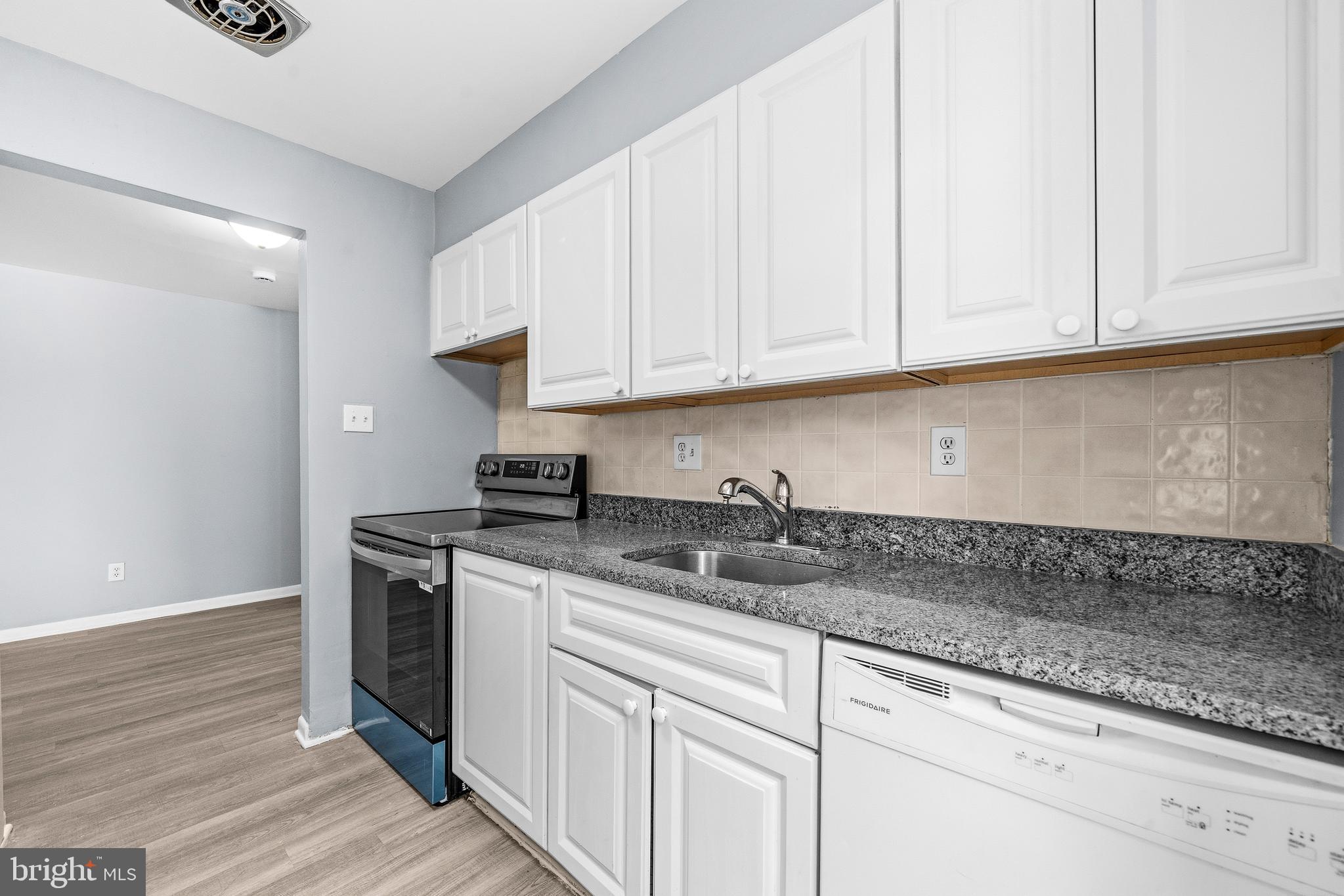 4260 Buckman Road, Unit 43 Alexandria, VA 22309 - Photo 11 of 35 a kitchen with stainless steel appliances granite countertop a sink a stove and dishwasher with wooden floor