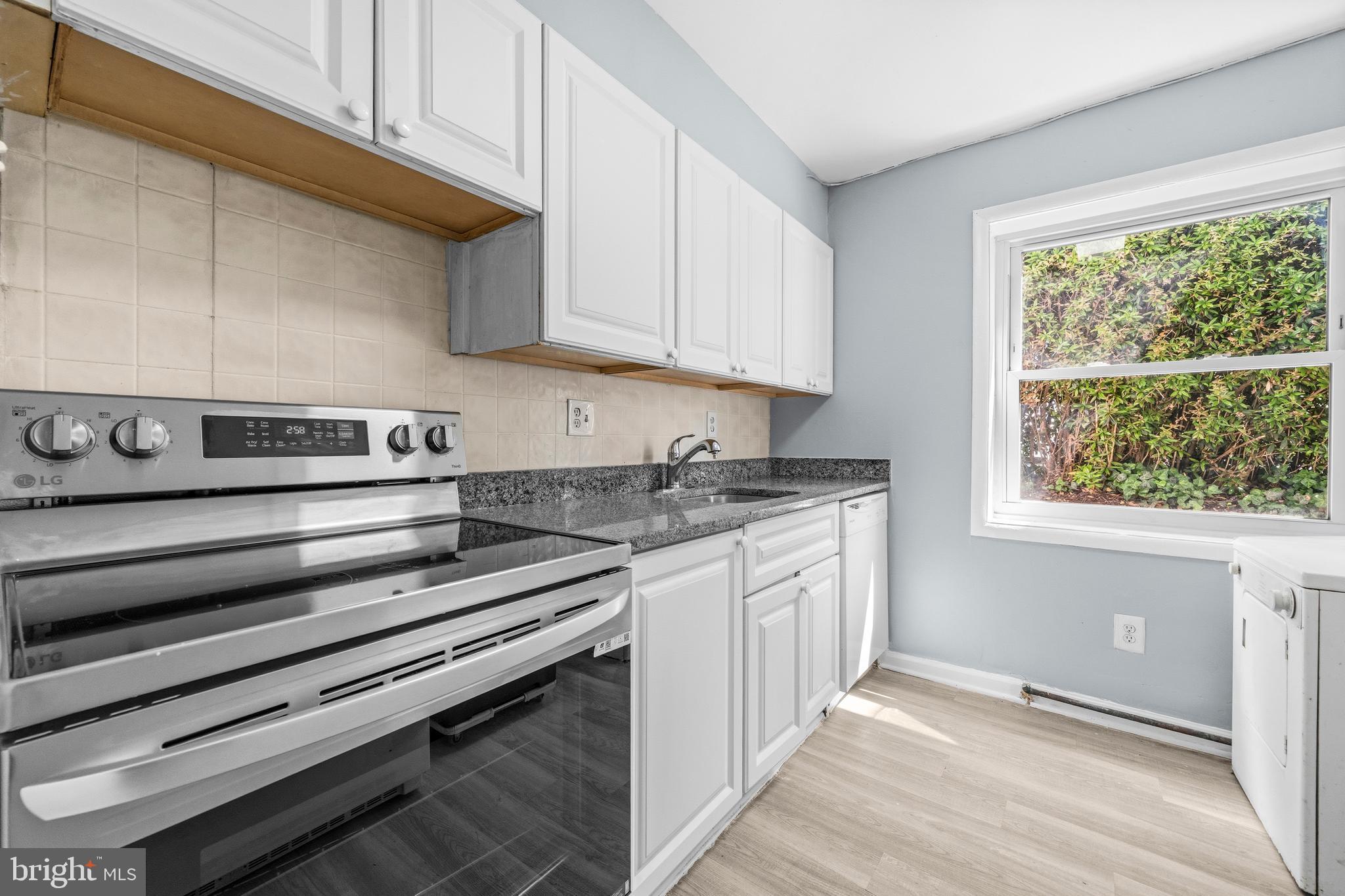 4260 Buckman Road, Unit 43 Alexandria, VA 22309 - Photo 12 of 35 a kitchen with granite countertop a stove and white cabinets