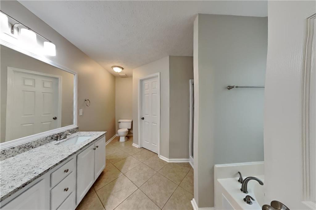 3366 English Oaks Drive Northwest Kennesaw, GA 30144 - Photo 12 of 22 a spacious bathroom with a granite countertop sink mirror and bathtub