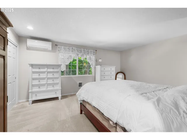 a bedroom with a bed a dresser and a couch