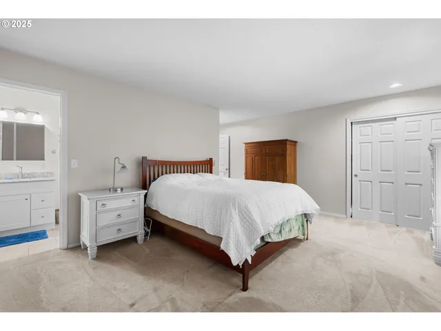 a spacious bedroom with a bed and a cabinets