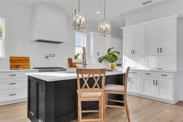a kitchen with white cabinets and appliances