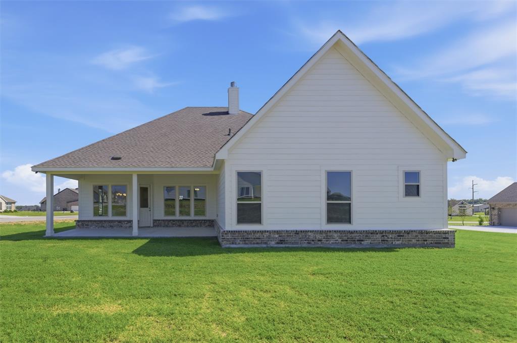 104 Snowy Owl Trail Rhome, TX 76078 - Photo 25 of 27 Rear exterior featuring a covered patio, white siding, and a stone accent foundation