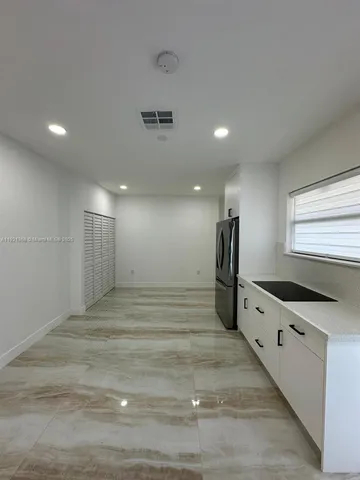 a kitchen with stainless steel appliances a stove a refrigerator and white cabinets