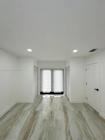 a view of a hallway with wooden floor and closet area