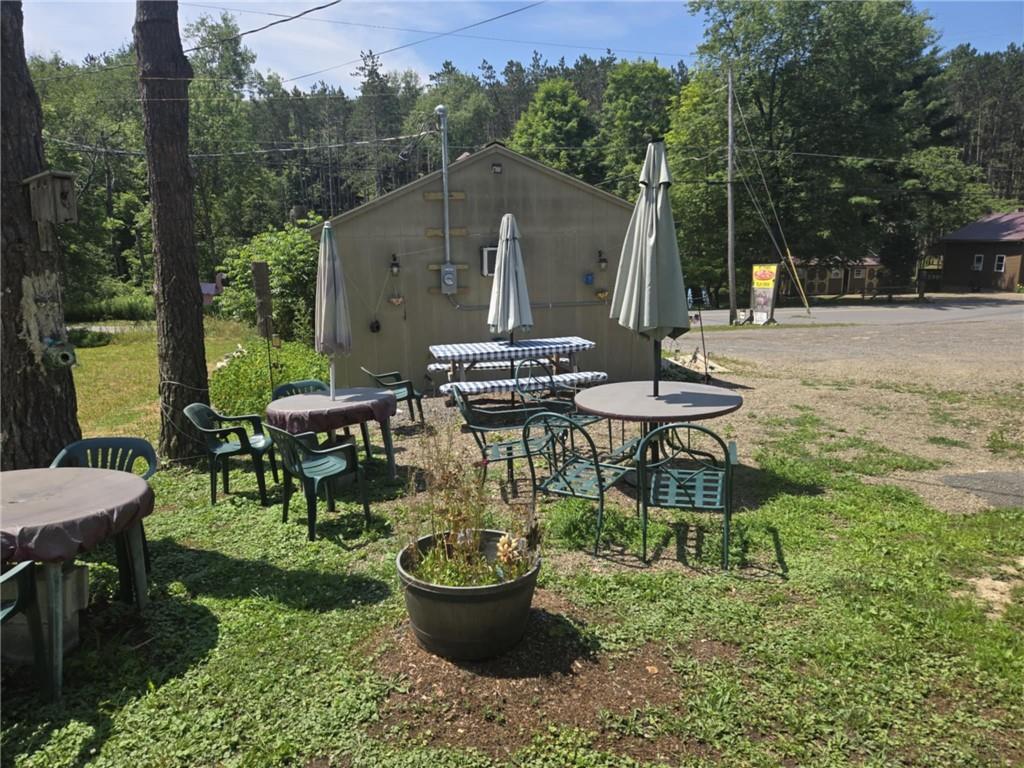 2879 Winslow Hill Road Benezett, PA 15821 - Photo 20 of 24 a view of a backyard with table and chairs potted plants and a palm tree
