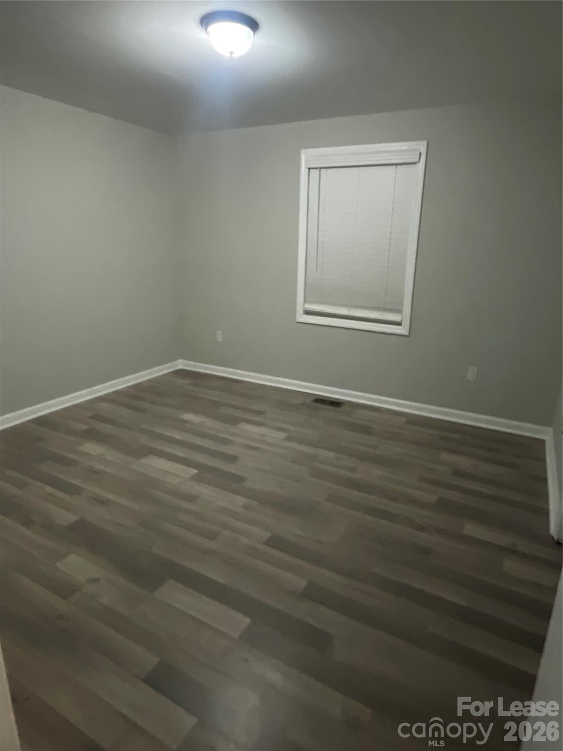 70 Barbee Road Southwest Concord, NC 28027 - Photo 5 of 7 a view of an empty room with wooden floor and a window