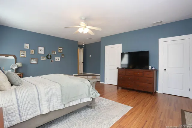 a bedroom with a bed and a flat tv screen on dresser