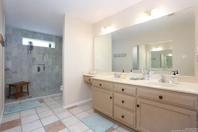 a spacious bathroom with a granite countertop sink mirror and shower