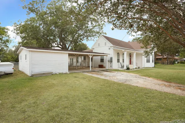 a front view of a house with a garden and trees