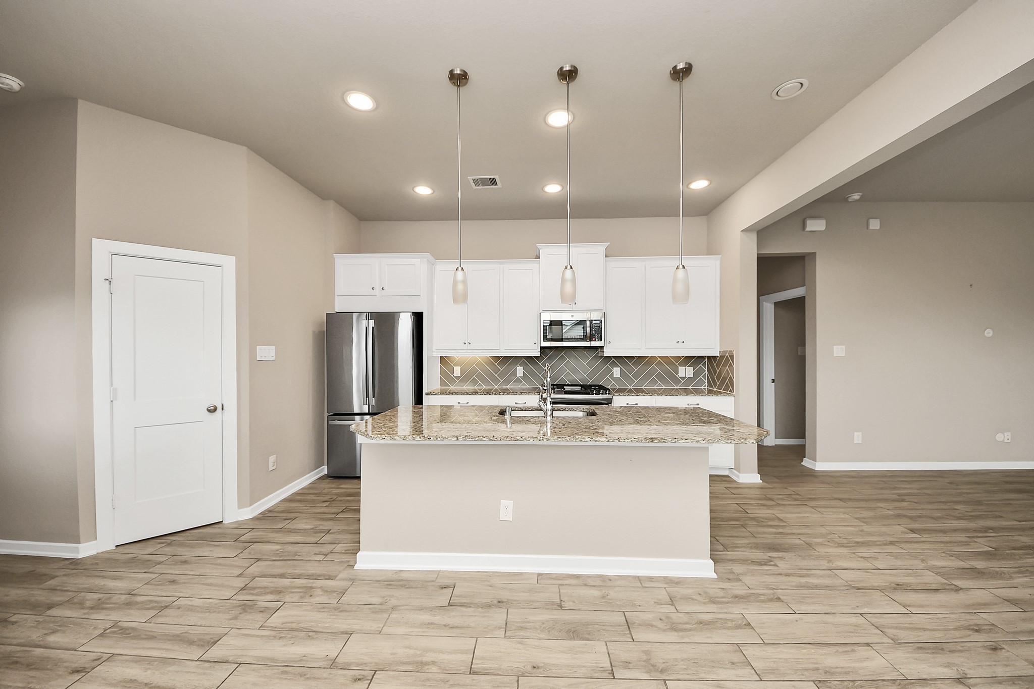 6030 Rivercane Way Katy, TX 77493 - Photo 19 of 41 The granite topped island will be the gathering place for your guest with counter height bar seating. The pantry is located on the left.