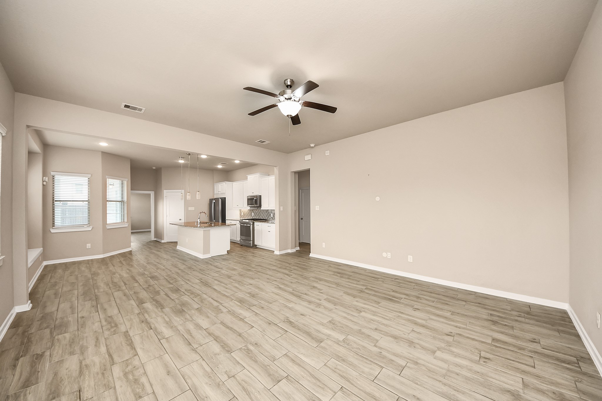 6030 Rivercane Way Katy, TX 77493 - Photo 6 of 41 Wood-look tile flooring and high ceilings carry seamlessly throughout the home. Lots of space for your furniture!