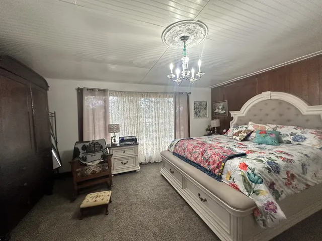 a spacious bedroom with a bed and a chandelier