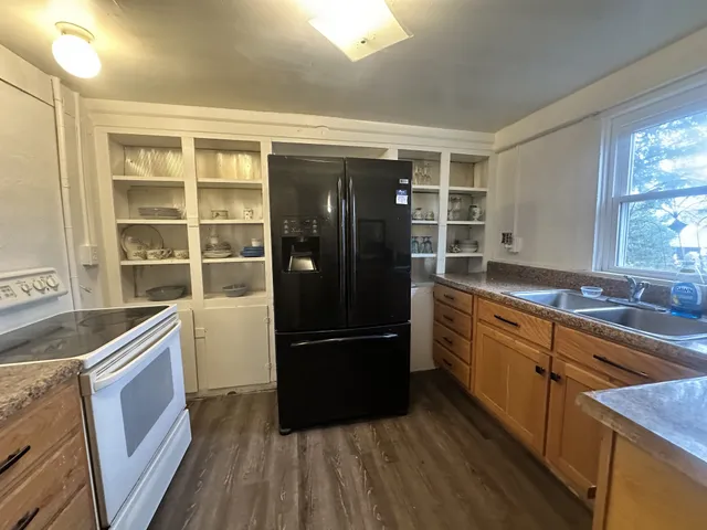 a kitchen with granite countertop a refrigerator and a sink