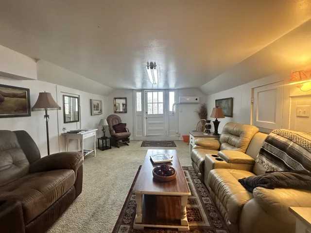 a living room with furniture a chandelier a flat screen tv and a window