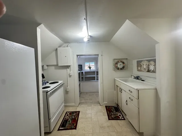a kitchen with granite countertop a sink stove and refrigerator