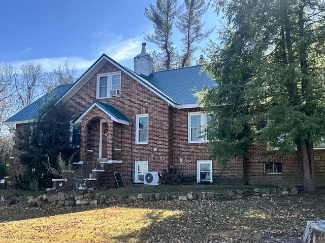 a front view of a house with yard tree and green space