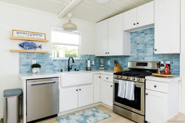 a kitchen with stainless steel appliances granite countertop a stove and white cabinets