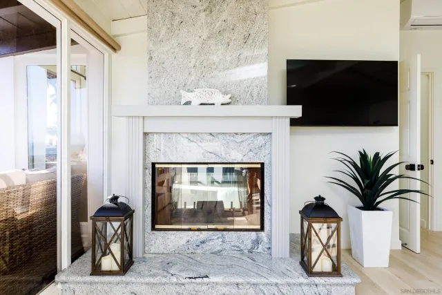 a living room with a fireplace and potted plants