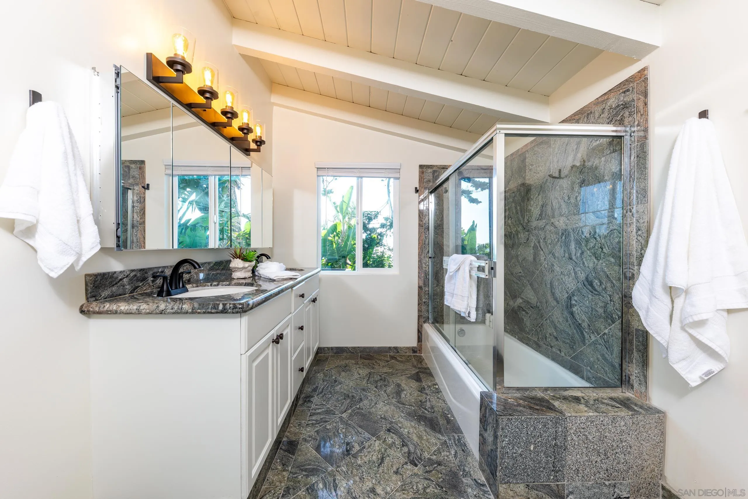 110 8th Street Del Mar, CA 92014 - Photo 34 of 45 a bathroom with a granite countertop sink a mirror and a bathtub