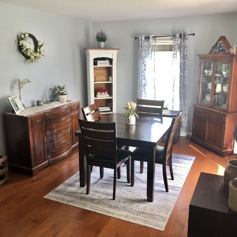 33 Bolton Road Clinton, MA 01510 - Photo 12 of 40 a dining room with wooden floor a chandelier a wooden table and chairs