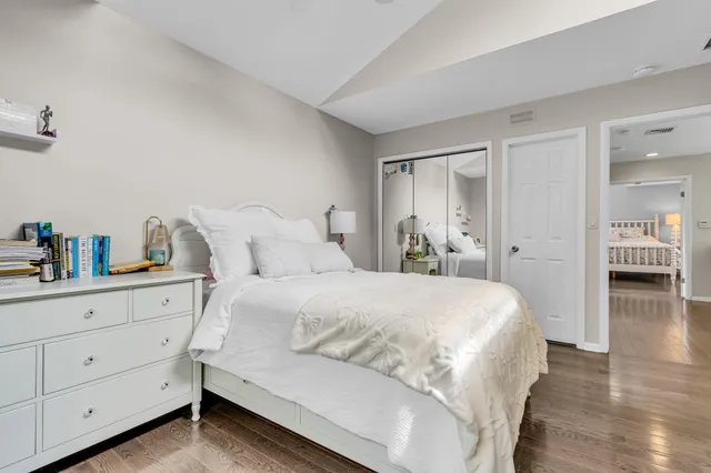 a bedroom with a large bed and wooden floor