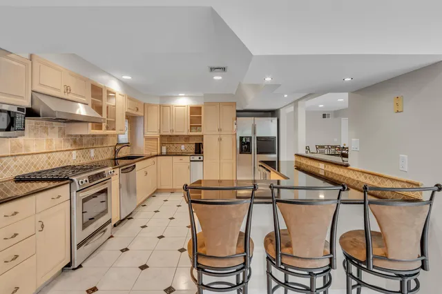 a kitchen with stainless steel appliances granite countertop a stove a sink and a refrigerator