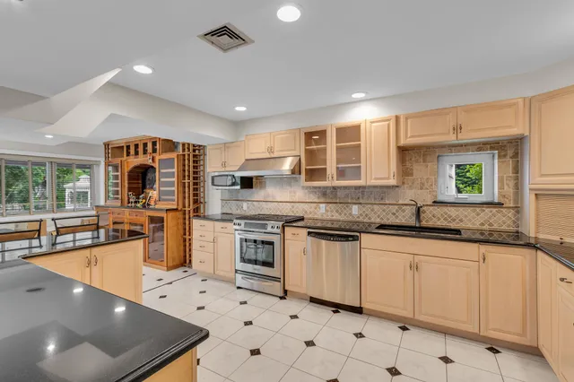 a kitchen with stainless steel appliances granite countertop a sink and stove