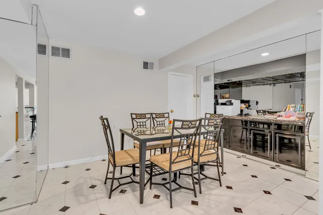 a kitchen with stainless steel appliances a table and chairs in it