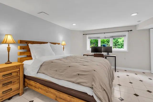 a large bed sitting in a bedroom next to a window