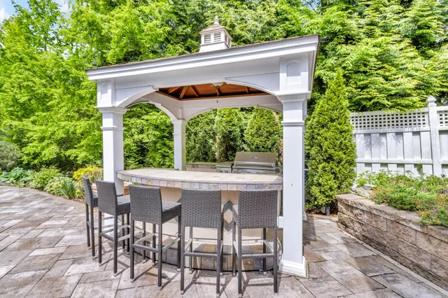 a patio with table and chairs and potted plants