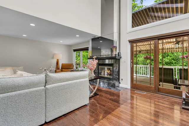 a living room with furniture a flat screen tv and a floor to ceiling window